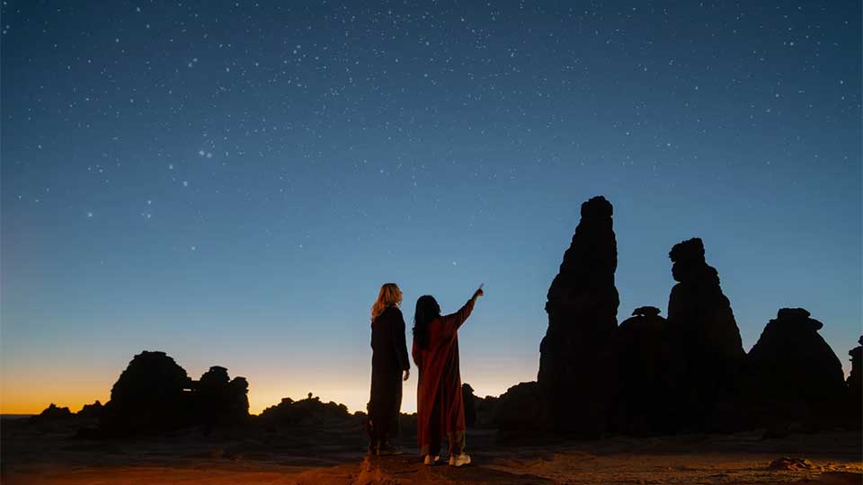 Two women admiring the rock formations in AlUla